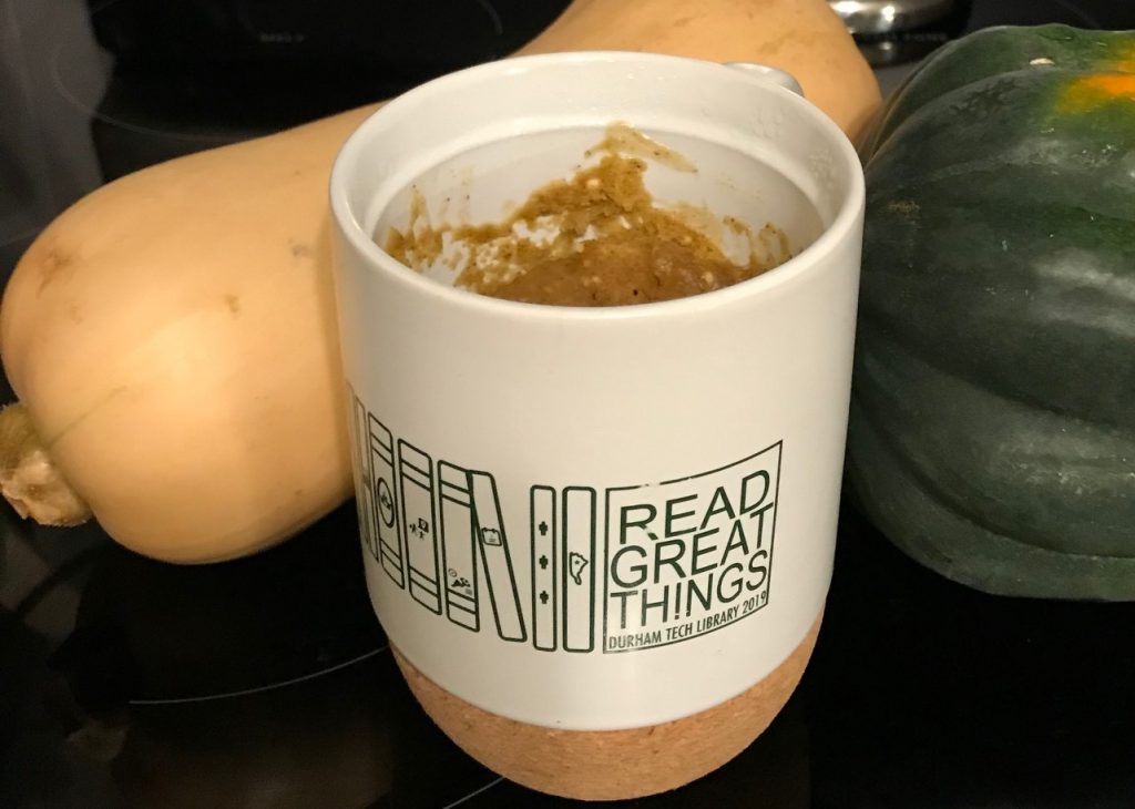 Pumpkin mug cake in Read Great Things 2019 mug with squashes in the background to add to the aesthetic
