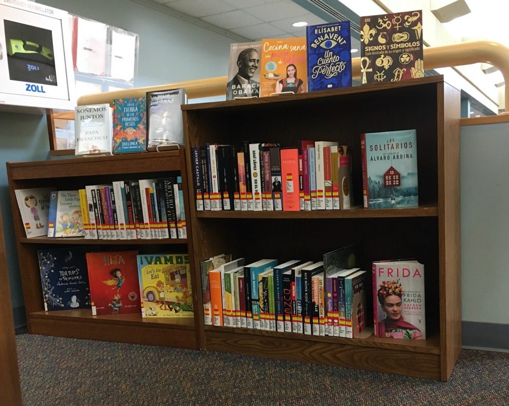 the display of new Spanish language books on bookshelf upstairs to the left of the stairs in the Main Campus Library
