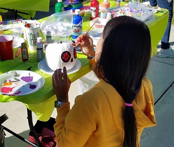 Student painting a pumpkin at a previous Crafternoon event.